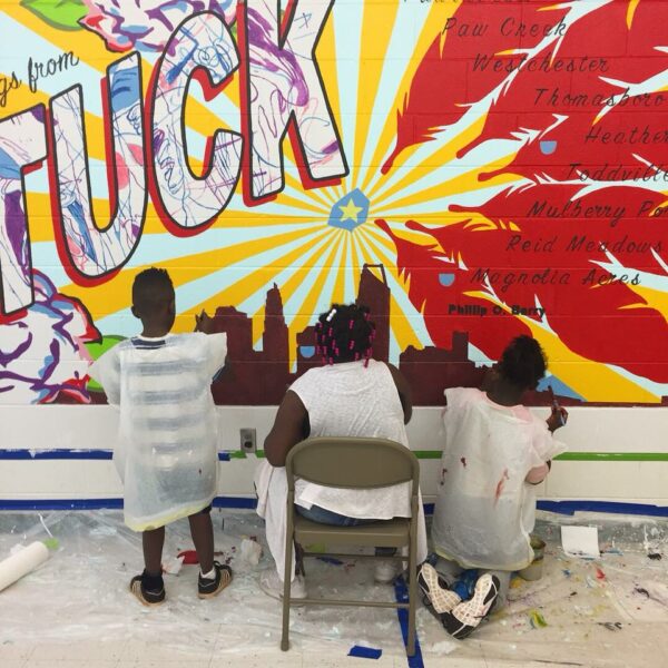 people painting mural that says Tuck