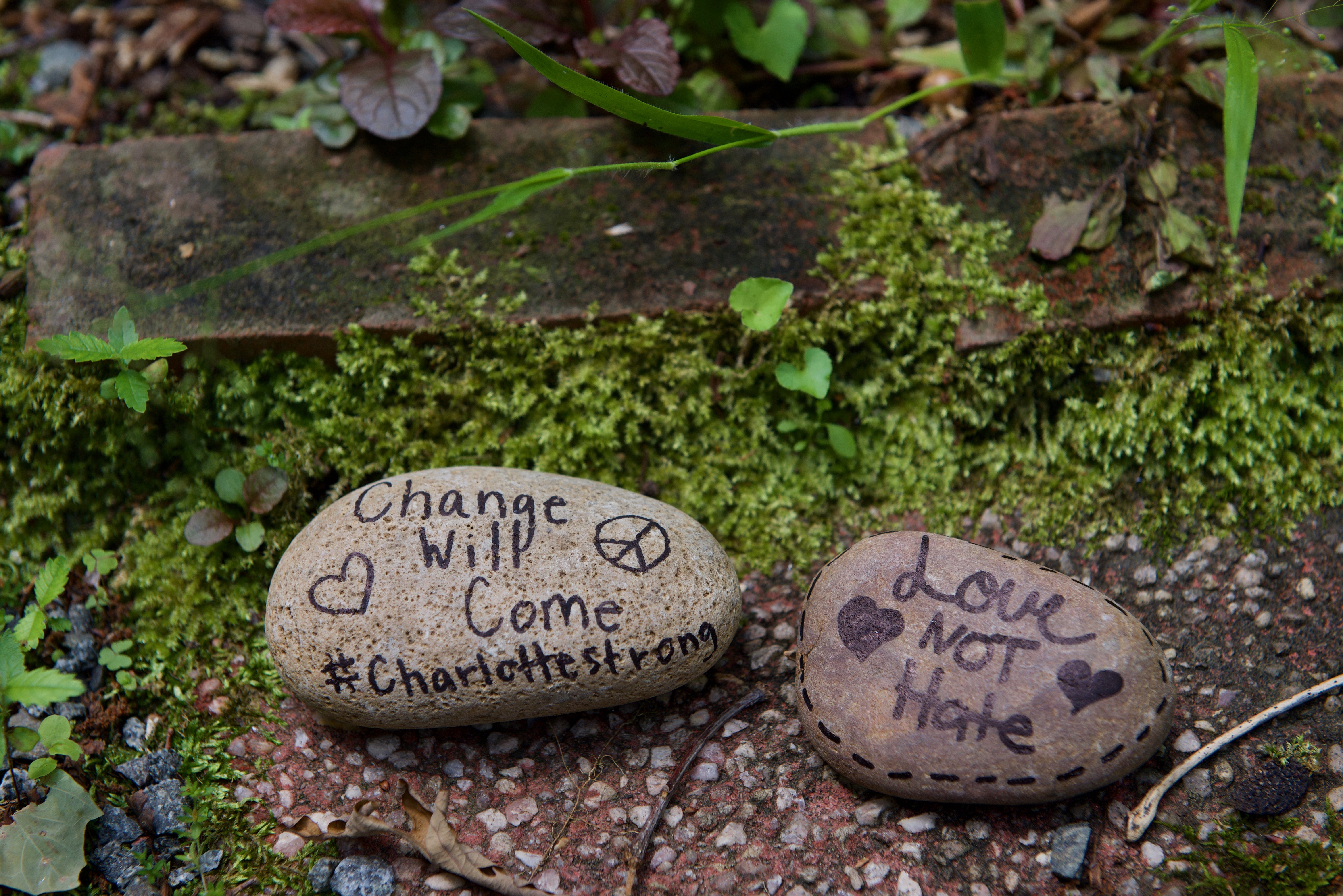 Stones with the messages Change Will Come #Charlotte strong and Love Not Hate